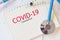 COVID-19 coronavirus concept with syringe injection medication drug and stethoscope on paper notebook Coronavirus spread influenza