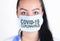 Covid-19 coronavirus desease global pandemic outbreak. A young female doctor in a medical mask with lettering. Close up portrait f