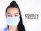 Covid-19 coronavirus desease global pandemic outbreak. A young female doctor in a medical mask with lettering. Close up portrait f
