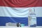 COVID-19 coronavirus disease vaccine vial and syringe against the Dutch flag. Medical research and vaccination in the