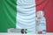 COVID-19 coronavirus disease vaccine vial and syringe against the Italian flag. Medical research and vaccination in