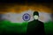 COVID-19 coronavirus epidemic in india. Silhouette man in medical mask on a background abstract indian flag. Global COVID-19