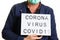 Covid-19 coronavirus text written over lightbox man face mask shocked by Corona virus pandemic