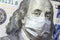 COVID-19 coronavirus in USA, 100 dollar money bill with face mask. COVID-19 affects global stock market