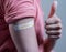 Covid-19 or coronavirus vaccinated shoulder with booster shot sticker and thumbs up gesture - concept of approved coronavirus 3rd