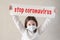 Covid-19 epidemic outbreak health care  with little girl in medical mask holding banner with stop coronavirus slogan text