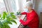 The Covid-19, health, safety and pandemic concept - senior old lonely woman sitting near the window