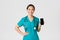 Covid-19, healthcare workers and online medicine concept. Professional female asian doctor, nurse in scrubs showing