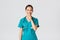 Covid-19, healthcare workers, pandemic concept. Cheerful, smiling female asian nurse in scrubs having secret, making