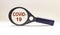 COVID-19 lettering on white background in magnifying glass World Health