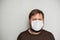 COVID-19 Pandemic Coronavirus. Portrait of a man with a beard in a white mask