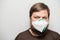 COVID-19 Pandemic Coronavirus. Portrait of a man with a beard in a white mask with a flap