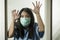 Covid-19 pandemic - young scared and frightened Asian Chinese woman in medical mask isolated suffering lockdown and quarantine