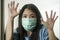 Covid-19 pandemic - young scared and frightened Asian woman in medical mask isolated suffering lockdown and quarantine during