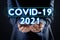 COVID-19 predictions for 2021 year. Man and text on dark background, closeup