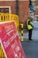 A COVID-19 sign saying road closure ahead with a workman in a hi-vis jacket stood in the background