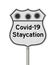 Covid-19 Staycation highway road sign with virus symbols