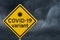 COVID-19 variant warning on a on yellow highway caution road sign