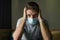 Covid-19 virus lockdown - sad and worried man covered with medical mask thinking and feeling scared in quarantine following stay