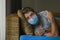 Covid-19 virus lockdown - sad and worried man in medical mask thinking and feeling scared in quarantine following stay at home