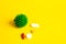 COVID-19 on a yellow background. New coronavirus infection. Image of a green coronavirus. Tablets, antibiotics against the disease