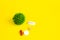 COVID-19 on a yellow background. New coronavirus infection. Image of a green coronavirus. Tablets, antibiotics against the disease