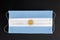 Covid outbreak in Argentina. Coronavirus update in Argentina. Flag of Argentina printed on medical mask on black background