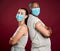 Covid vaccinated African american man and mixed race woman standing back to back. Two people wearing surgical face mask