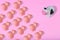 Cow in front of several small cute pigs on pastel pink background