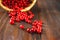 Cowberry, foxberry, cranberry, lingonberry sips from the basket on a brown wooden table.