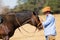 Cowboy feeding his horse