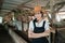 cowboy girl with crossed hands while wearing a hat in a cow stable