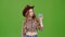 Cowboy girl in a hat and plaid shirt shows a finger down. Green screen