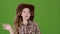 Cowboy girl in a leather hat sings into a retro microphone. Green screen. Slow motion