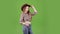 Cowboy girl puts on a hat on her head and wink. Green screen