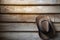 A cowboy hat hangs on grunge wooden wall