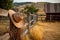 a cowboy hat hangs on a wooden fence against the backdrop of the setting sun.