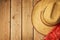 Cowboy hat on wooden vintage table with red bandanna for party invitation.