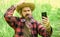 Cowboy hipster in field with smartphone. Social networks. Video call. Internet available in most remote corners of