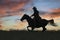 Cowboy on horseback against dawn sky,silhouette