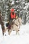 Cowboy hunter riding white horse in snow