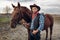 Cowboy poses with horse on texas farm
