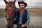 Cowboy poses with horse on texas farm