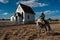 Cowboy rests his horse in front of an old church in rural area of New Mexico.
