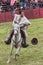 cowboy rides his horse while throws lasso