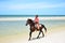 Cowboy is riding Horse walk on the beach