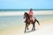Cowboy is riding Horse walk on the beach