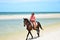 Cowboy is riding Horse walk on the beach