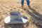 Cowboy standing near felt hat on wheat field