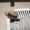 A cowboy wicker hat on a white bench with a striped vintage cushion in the garden Marche, Italy